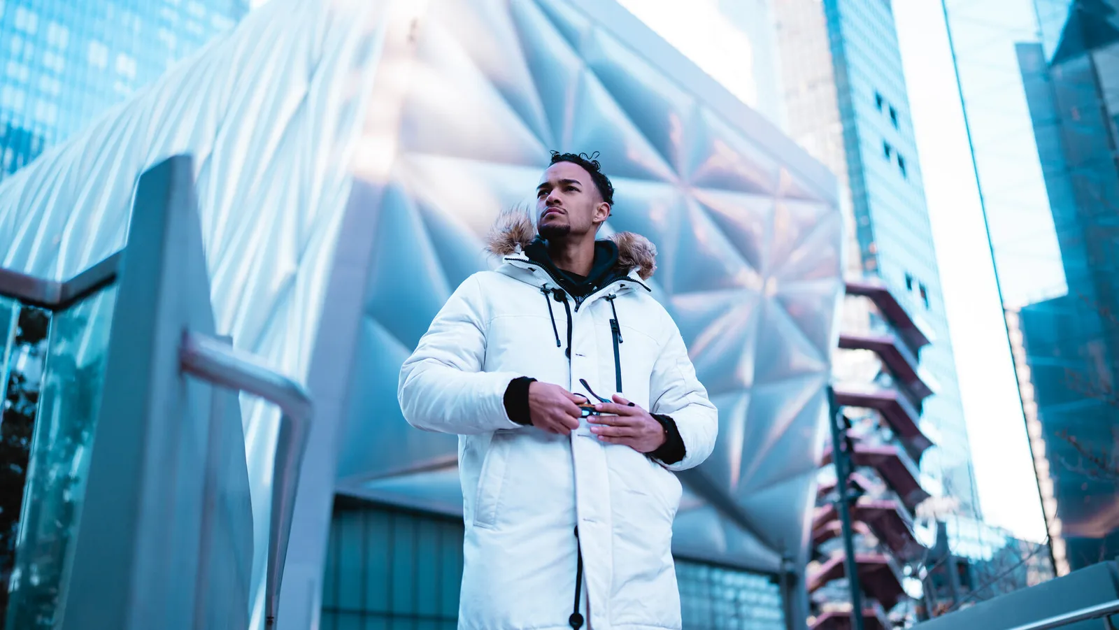 Subject in a white winter coat against a glass facade