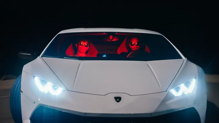 White supercar with headlights on at night