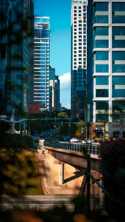 Glass towers above a riverside walkway