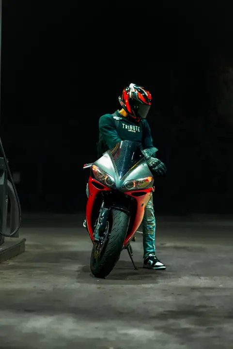 Rider beside a sport motorcycle at night