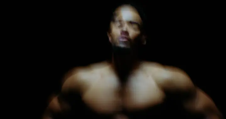 Torso emerging from shadow under a single light