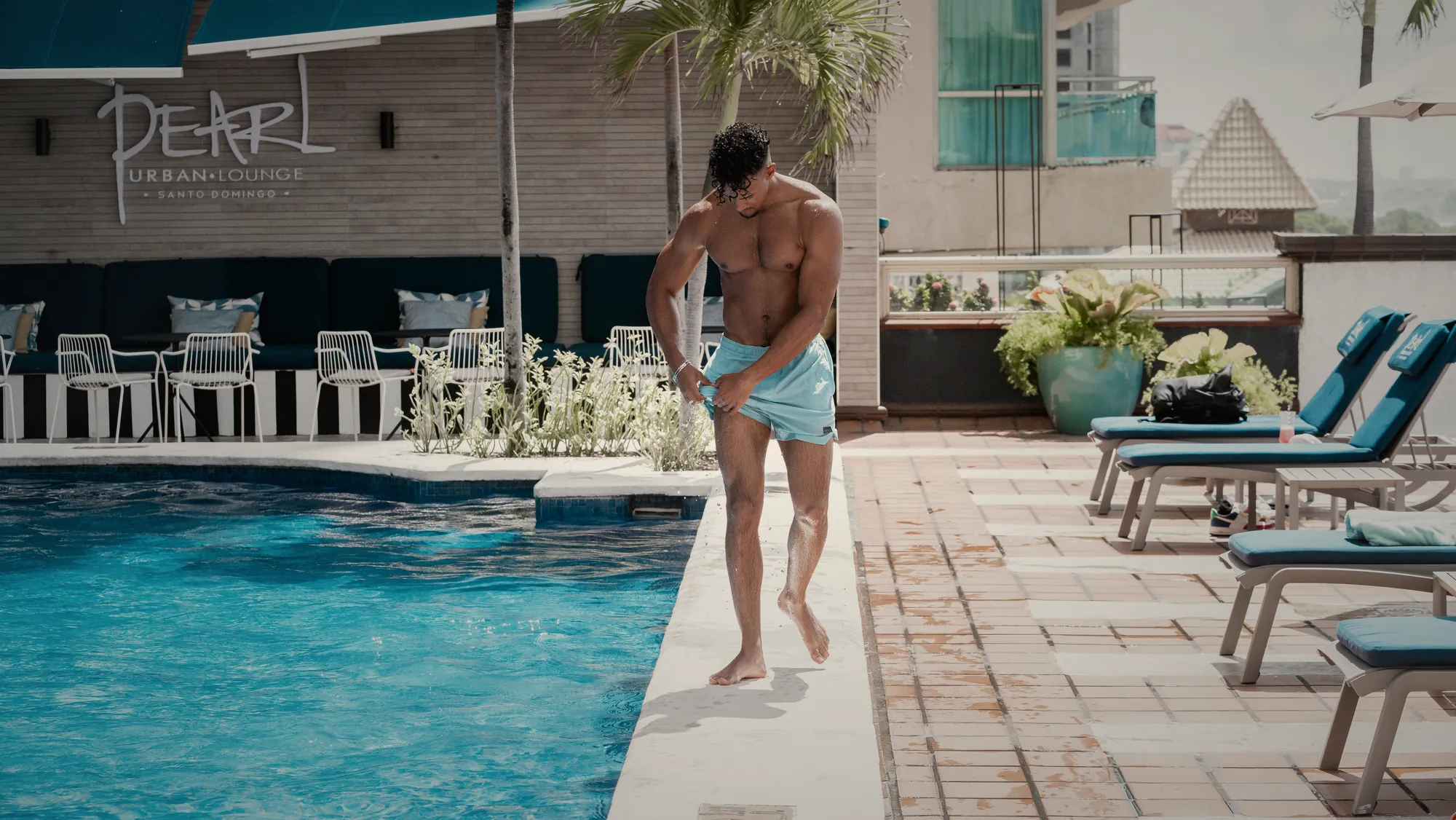 Model walking the edge of a rooftop pool at Pearl Urban Lounge, Santo Domingo
